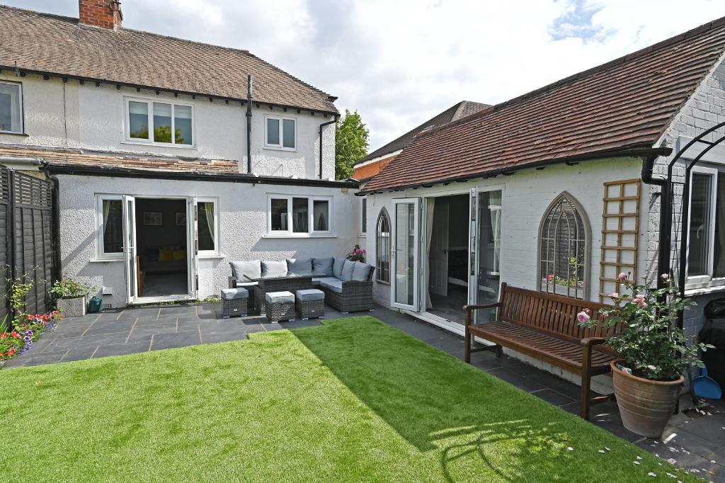 un patio con un banco y una casa en Central Townhouse with FREE onsite EV parking, en Stratford-upon-Avon