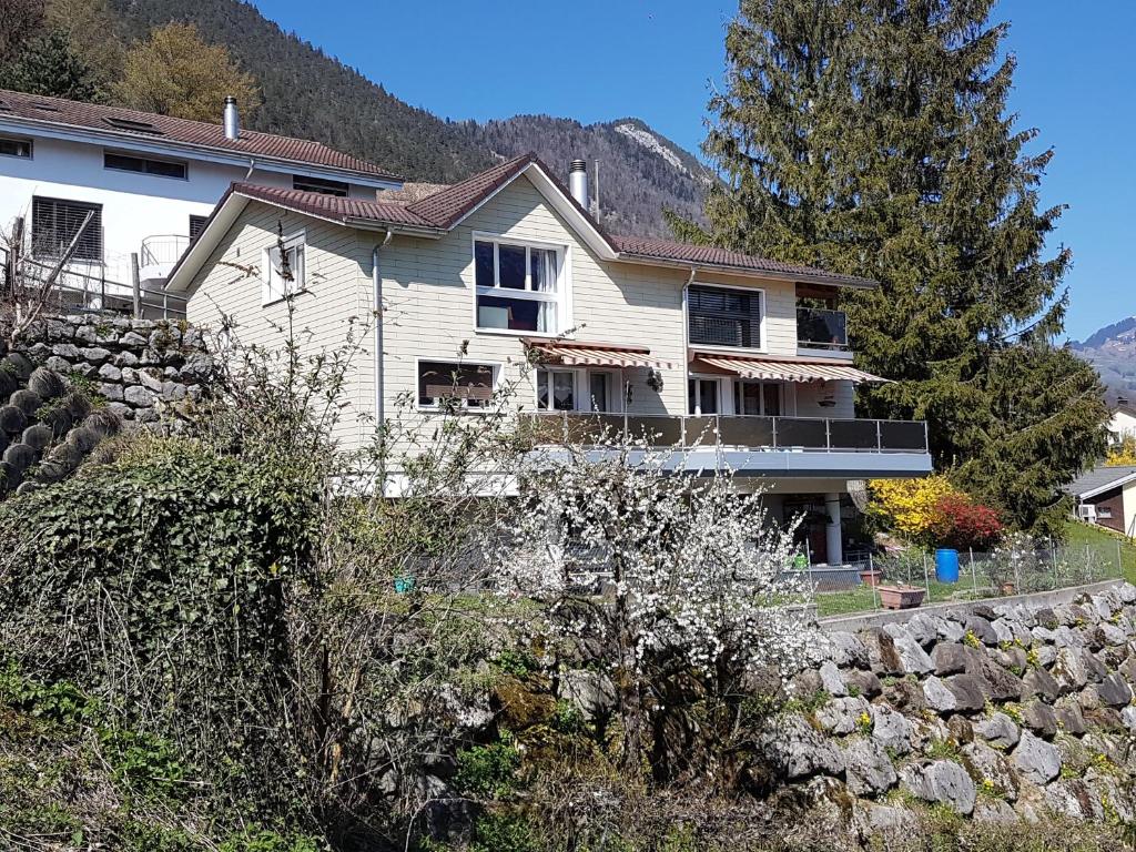 a house on a hill with a stone wall at Ferienwohnung Bally in Brunnen