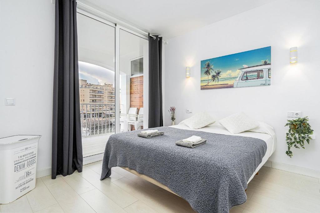 a white bedroom with a bed and a large window at Apartamento WELCS EMP 004 con inmejorables vistas in Empuriabrava