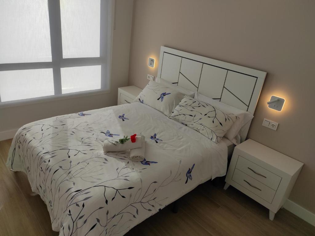 Un dormitorio con una cama blanca con pájaros azules. en Nature Beach and relax in illa de Arousa, en A Illa de Arousa