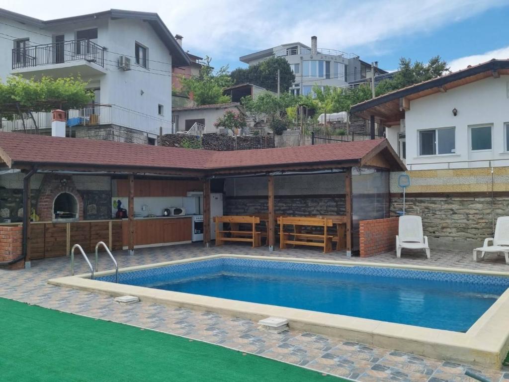 a swimming pool in front of a house at Къщи за гости Евита - град Балчик in Balchik