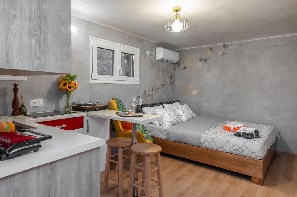 małą sypialnię z łóżkiem i kuchnią w obiekcie Cozy tiny apartment in the heart of Plaka w Atenach