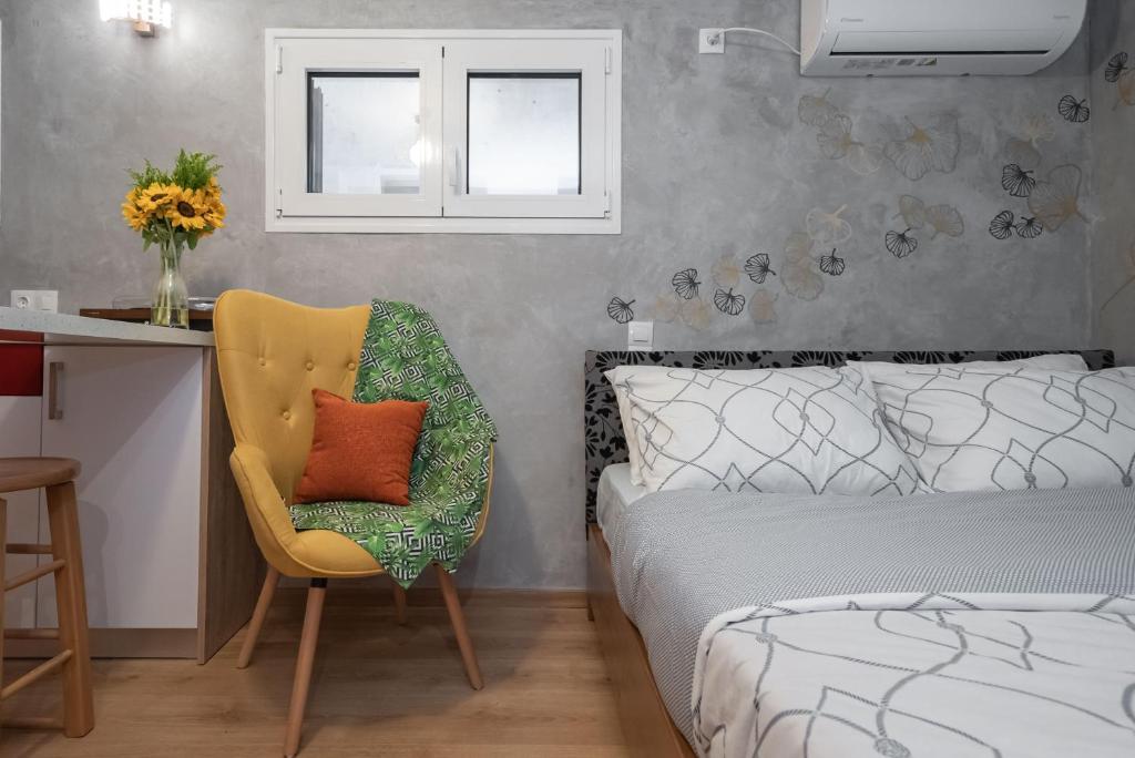 sypialnia z łóżkiem, krzesłem i biurkiem w obiekcie Cozy tiny apartment in the heart of Plaka w Atenach
