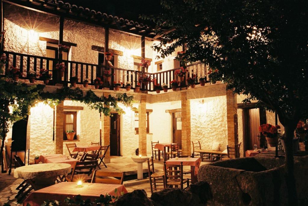a restaurant with tables and chairs in front of a building at Hotel Labranza in San Martín de Valdeiglesias
