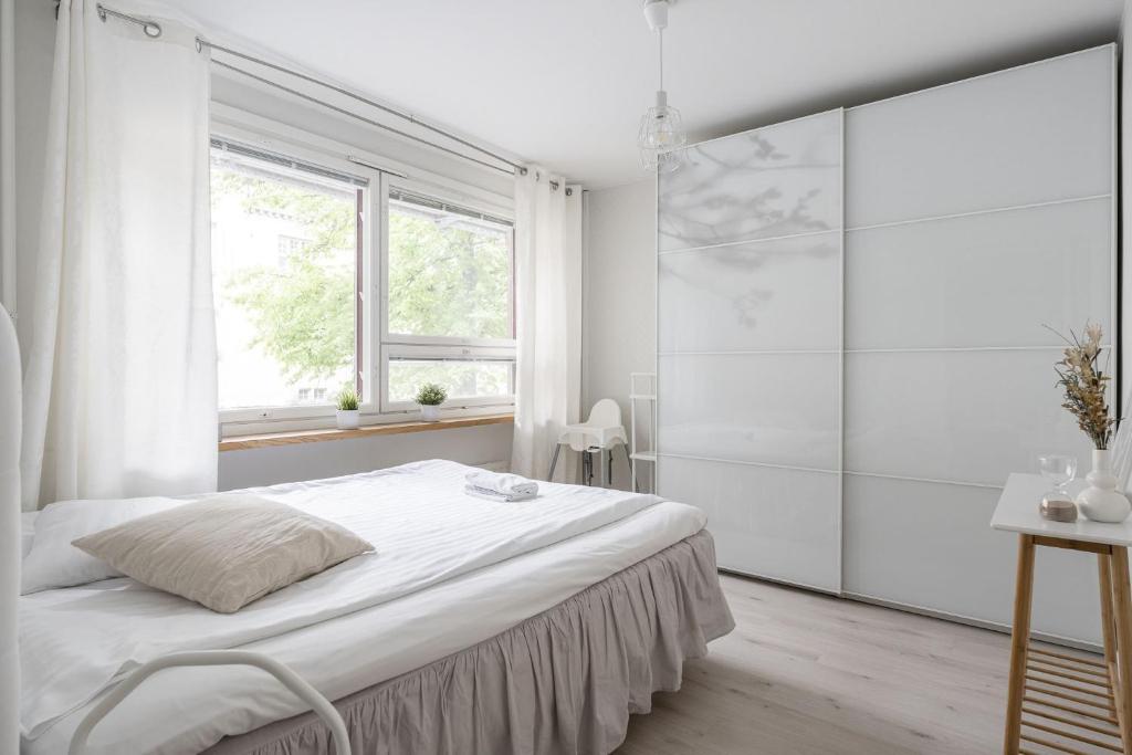 ein weißes Schlafzimmer mit einem Bett und einem Fenster in der Unterkunft 2ndhomes Tampere "Pieni Verka" Apartment - Superior Downtown Apt Near Restaurants in Tampere