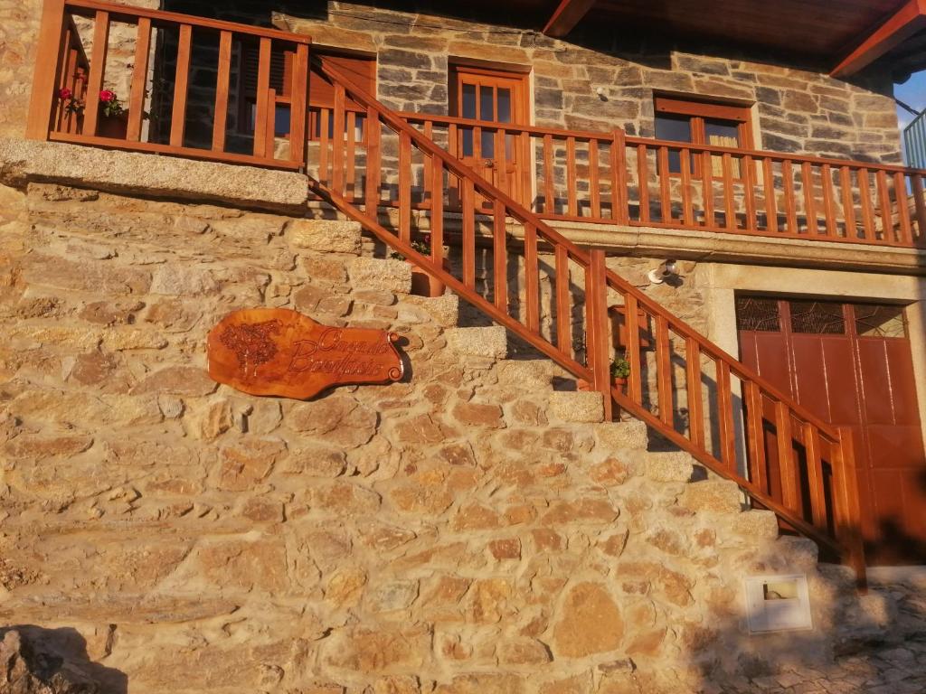 a stone building with a wooden staircase on it at Casa do Bonifácio in Vilarinho