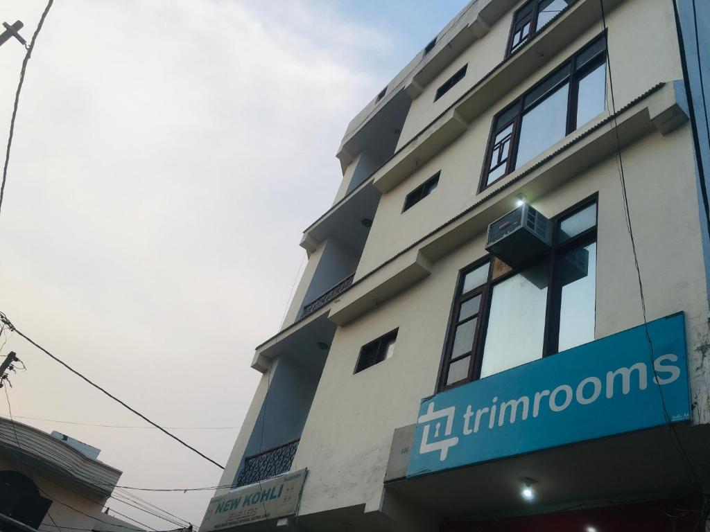 a building with a blue sign on the side of it at Trimrooms Shree Mata Palace, Katra Bus Stand in Katra