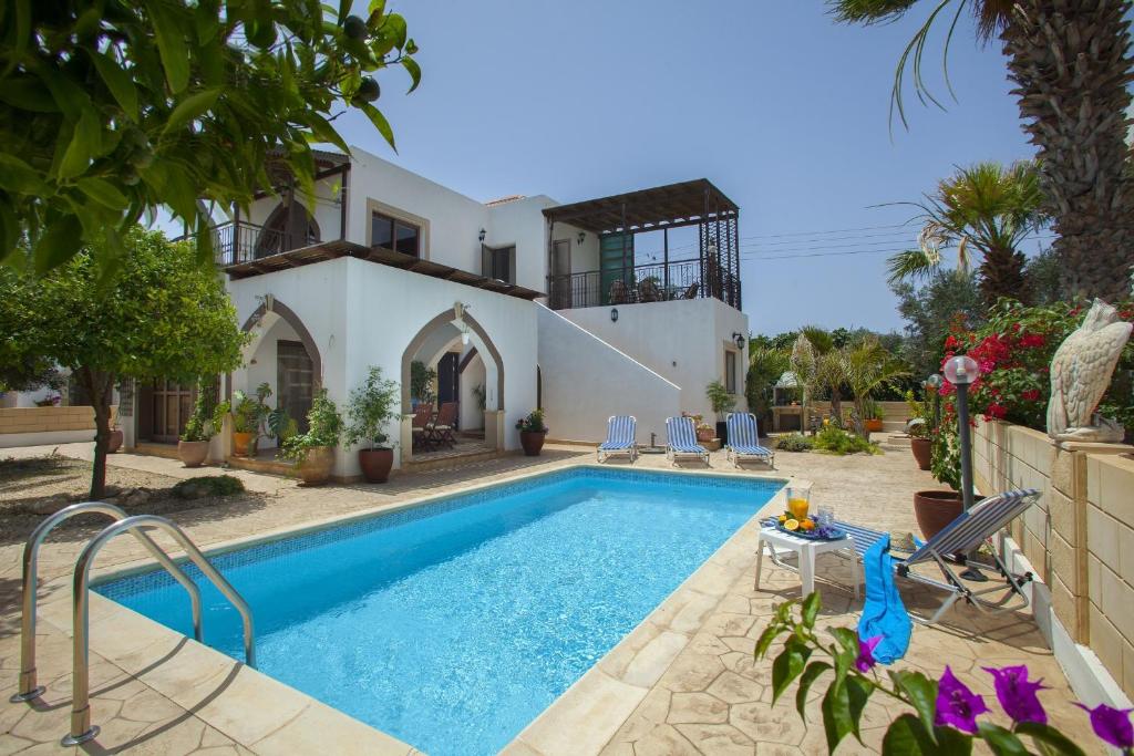 a villa with a swimming pool in front of a house at Villa Euphoria in Protaras
