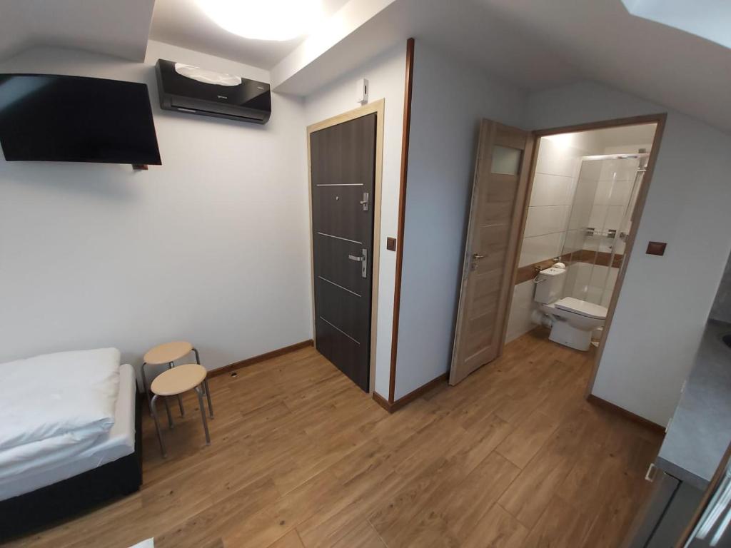 Cette petite chambre comprend un lit et des toilettes. dans l'établissement Apartamenty MARGO, à Chrzanów