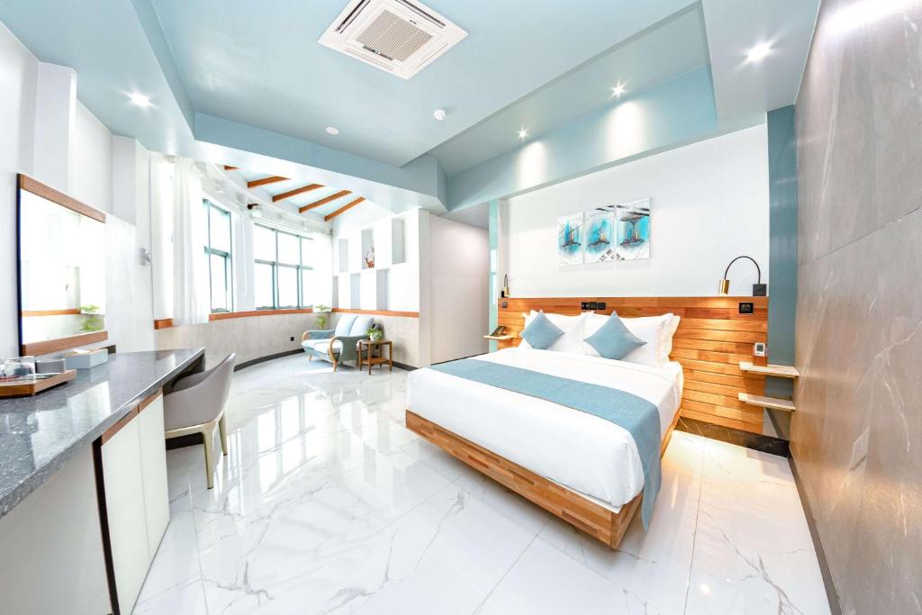 een hotelkamer met een bed en een bureau bij Marukab Plaza in Male City