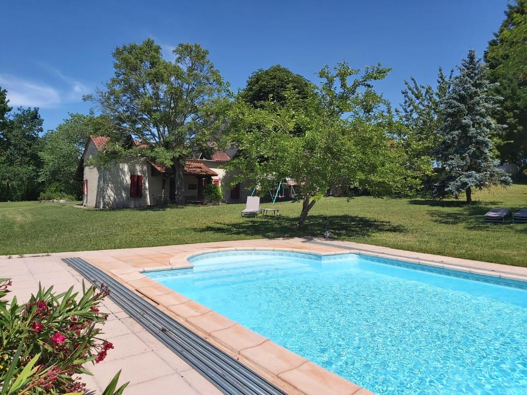 una piscina en un patio con una casa en Gîte Tissendie, en Bourg-de-Visa