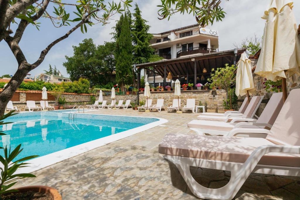 a pool with chaise lounge chairs and a house at VILLA SOL in Sunny Beach