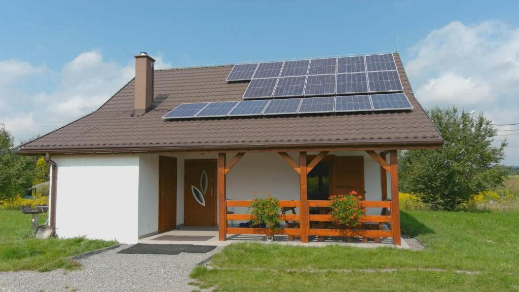 a small house with solar panels on the roof at Domek przy Gościńcu in Golczowice