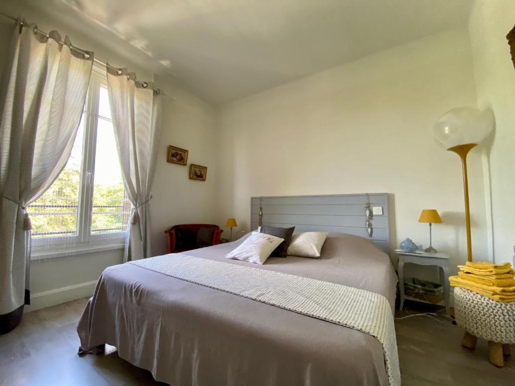 Un dormitorio con una cama grande y una ventana en GRAND F3 2 Ch CALME CONFORT PARKING RIVE GAUCHE CREPS HIPPODROME GOLF, en Bellerive-sur-Allier