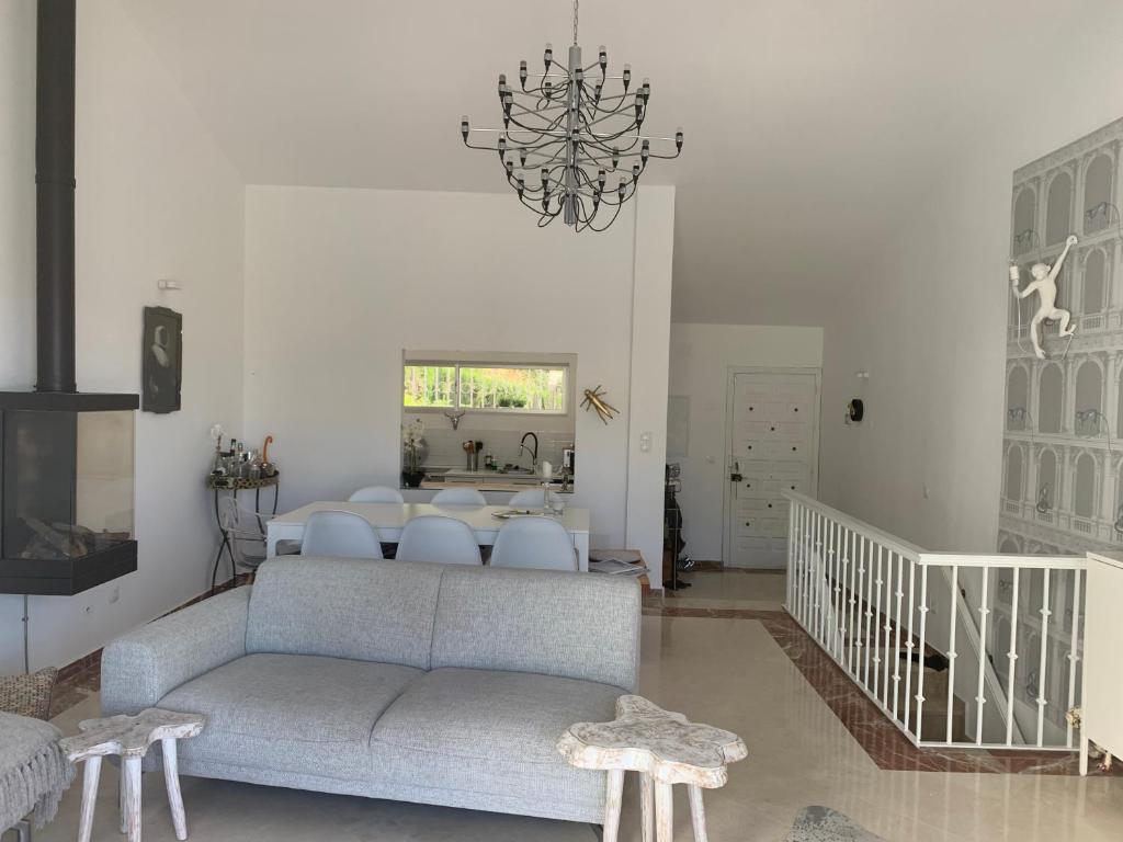 un soggiorno con divano e lampadario pendente di Casa Strack a Estepona