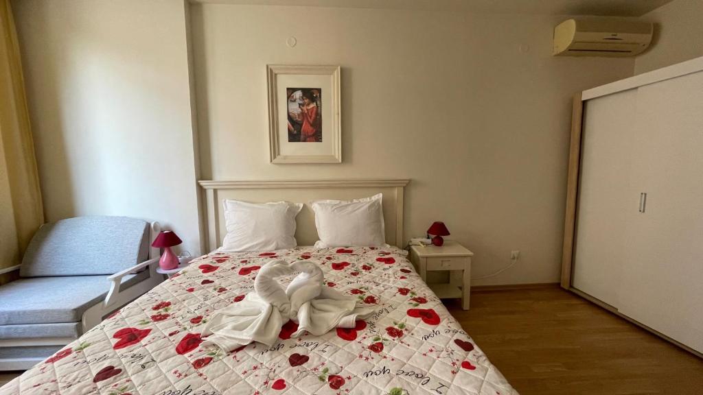 ein Schlafzimmer mit einem Bett mit einer Blumendecke in der Unterkunft SUN APARTMENTS 14 Studio Sunny Beach in Sonnenstrand