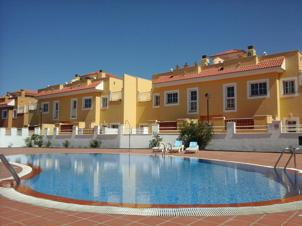 a large swimming pool in front of a building at Sol y Luz in Caleta De Fuste