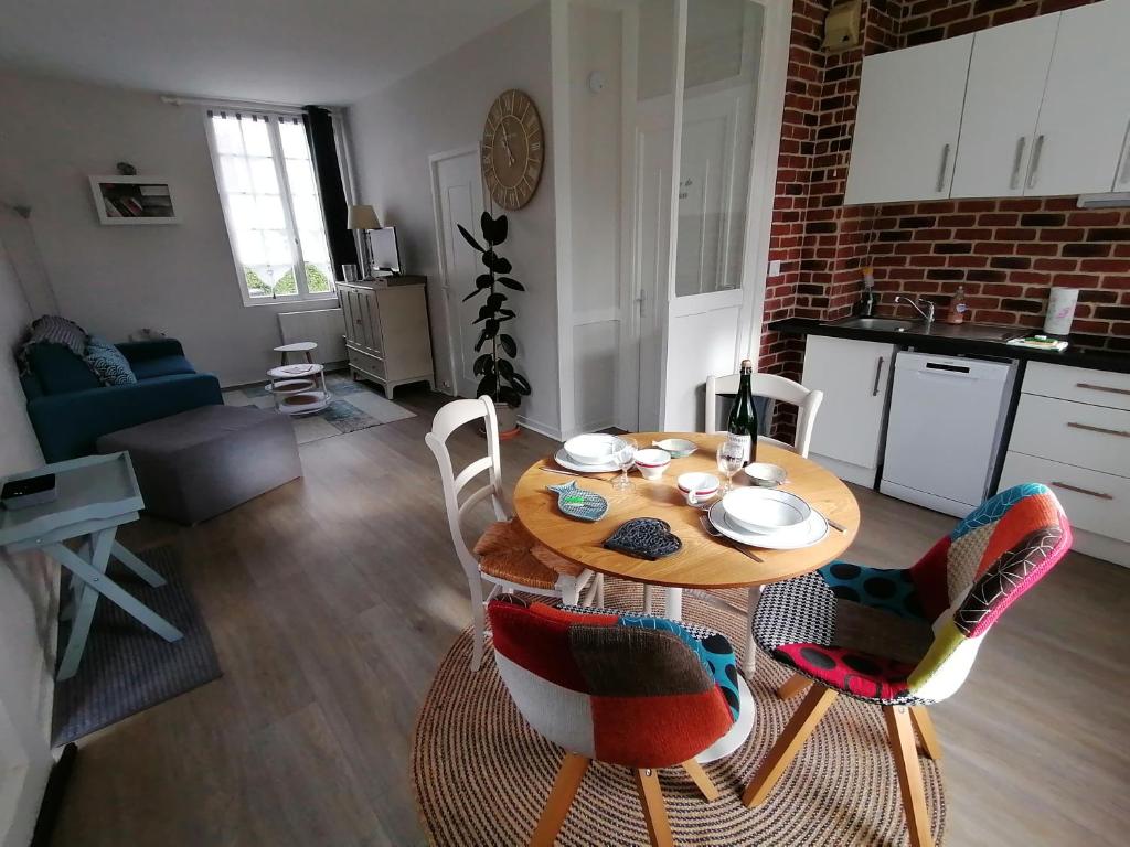 een eettafel en stoelen in de woonkamer bij A la "Georgette" et son jardin avec parking in Villers-sur-Mer