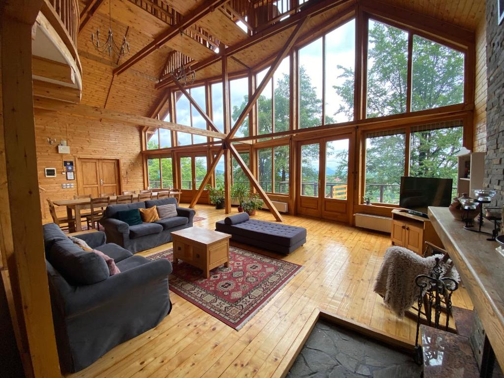 a living room filled with furniture and a large window at Carpathian Log Home in Bran