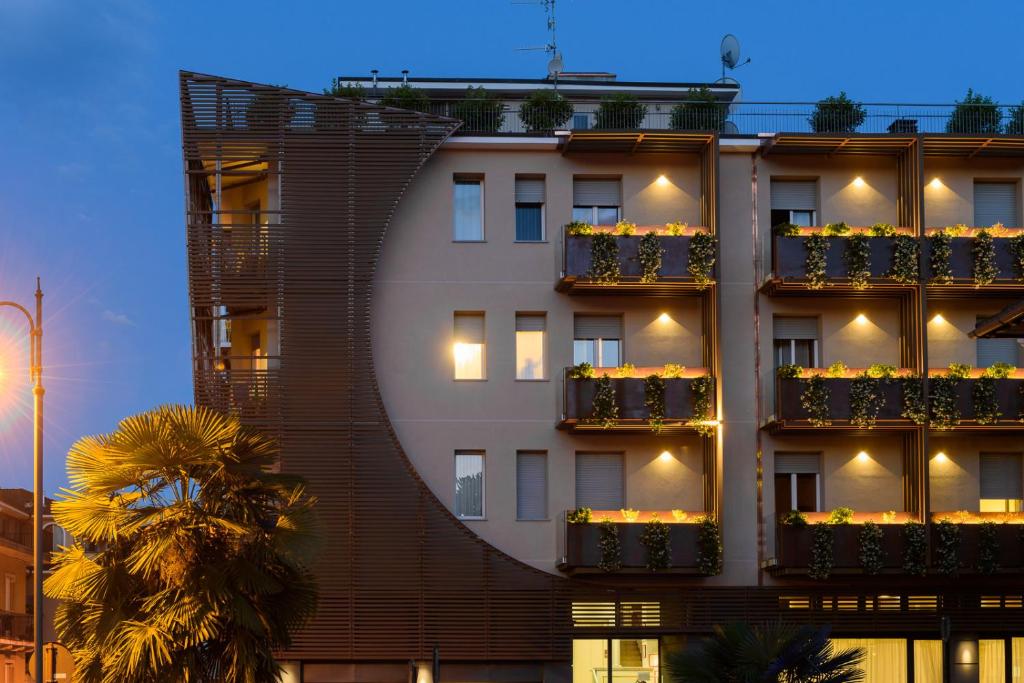 um edifício com caixas de flores ao lado em Hotel Meeting em Stresa