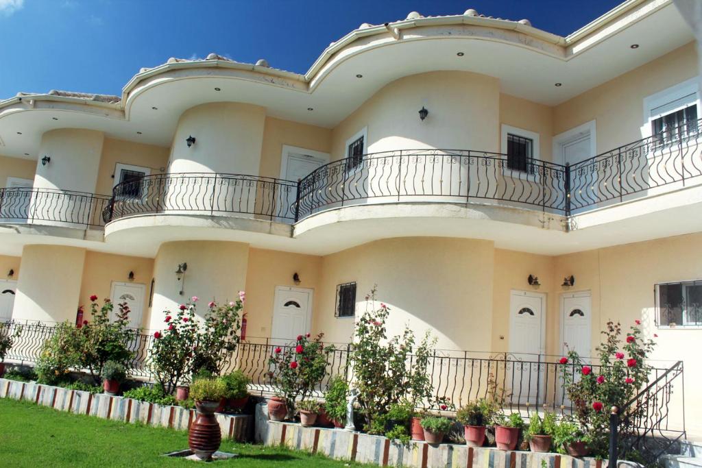un grande edificio con balconi e fiori in un cortile di ILEKTRA Apartments Blue & Red a Plataria