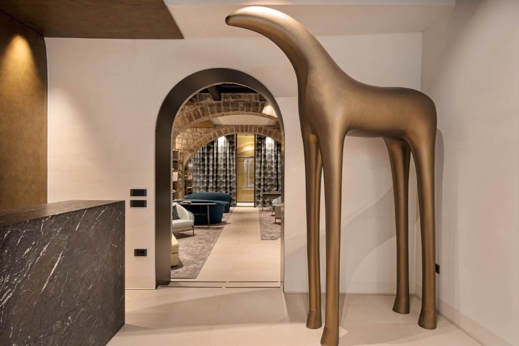 een gouden sculptuur van een giraf in een gang bij PALAZZO UBERTINI Urban Suites in Viterbo