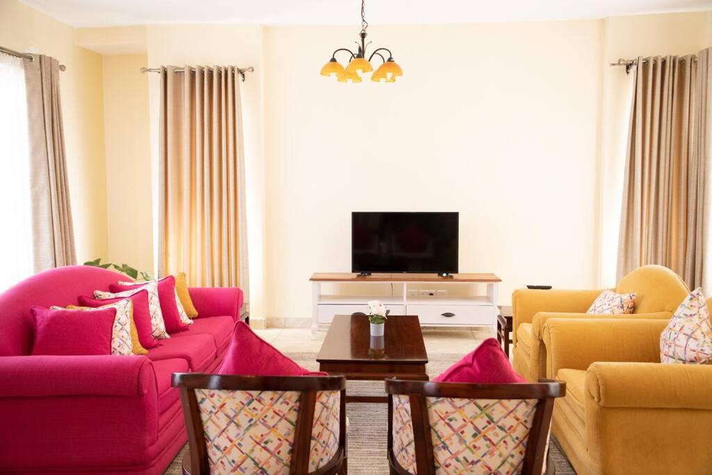 a living room with a couch and a tv at Cottage in Nanyuki, Maiyan; Swara Ranch #28 in Nanyuki