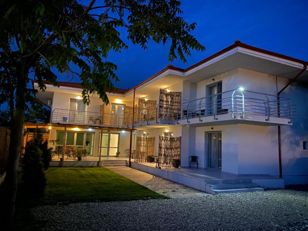 a white house with a balcony at night at VAMA BLUE in Vama Veche