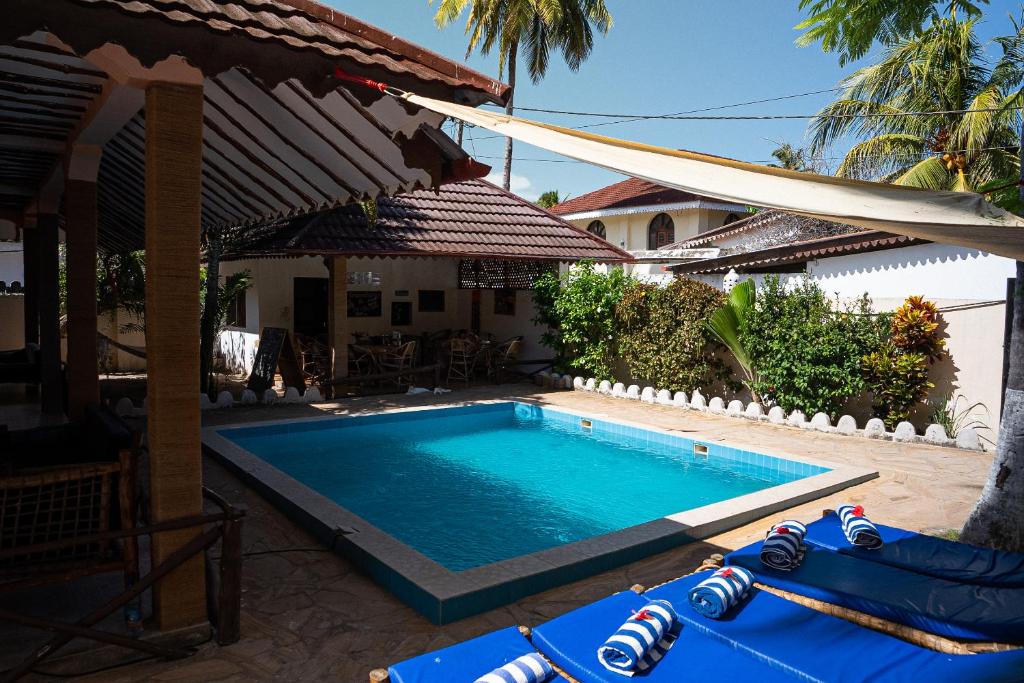 a swimming pool in front of a house at Hakuna Matata Villa in Paje