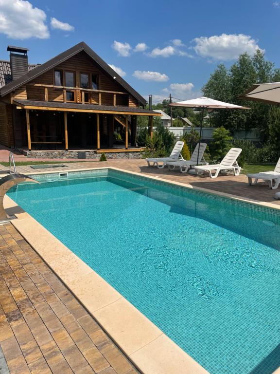 a swimming pool in front of a house at Le RoSA in Brailiv
