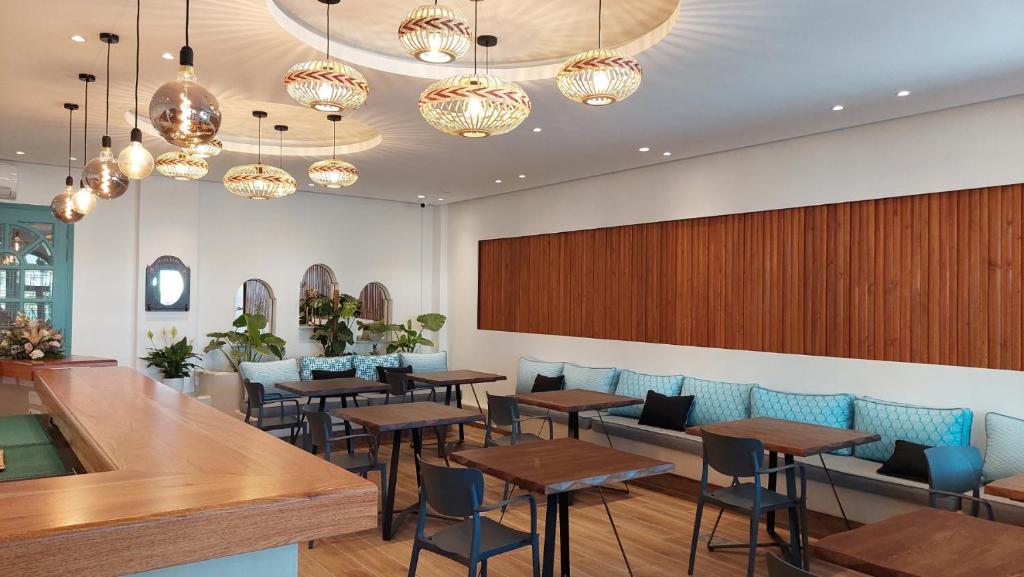 a restaurant with tables and chairs and chandeliers at Armonia in Kamari