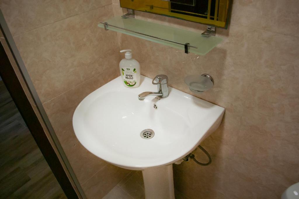 a bathroom sink with a bottle of soap on it at Жемчужина у моря in Batumi