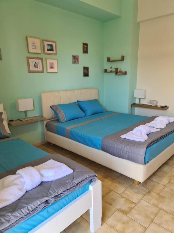 2 camas en un dormitorio con paredes azules en Seaside Apartments in Xilokastro, en Xylokastro