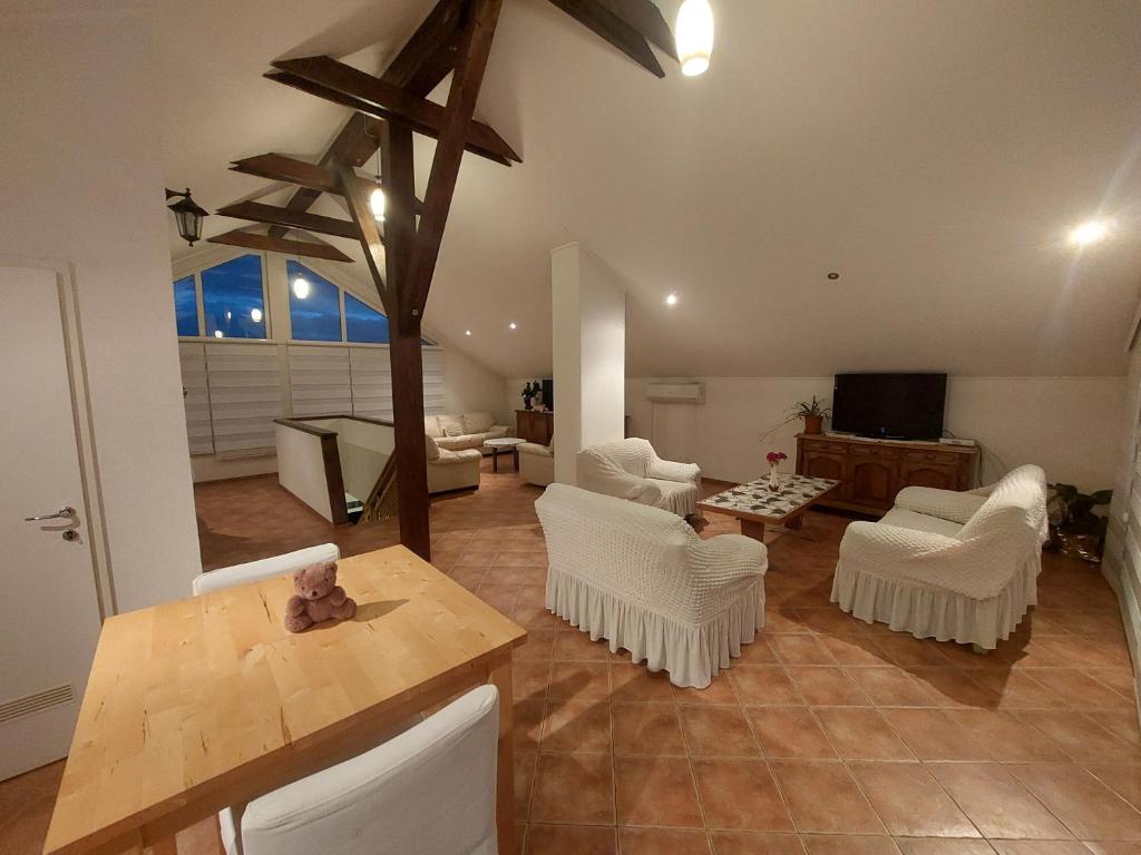 ein Wohnzimmer mit weißen Stühlen und einem Tisch in der Unterkunft Apartments Ilidža in Sarajevo