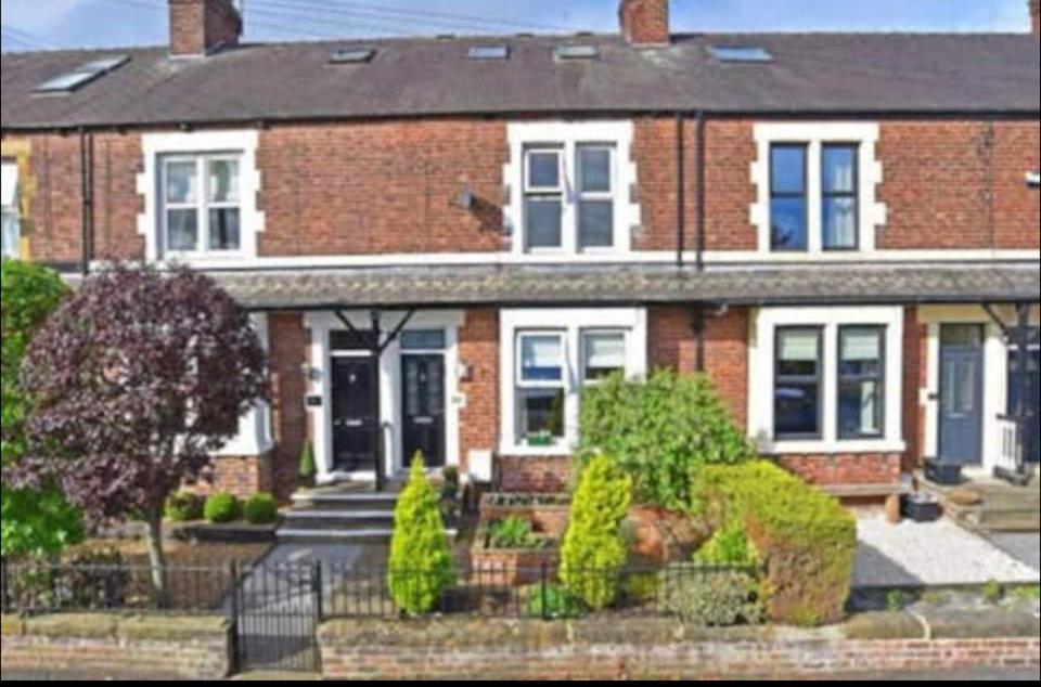 une maison en briques rouges avec une porte noire dans l'établissement Stonefall Home Stay, à Harrogate