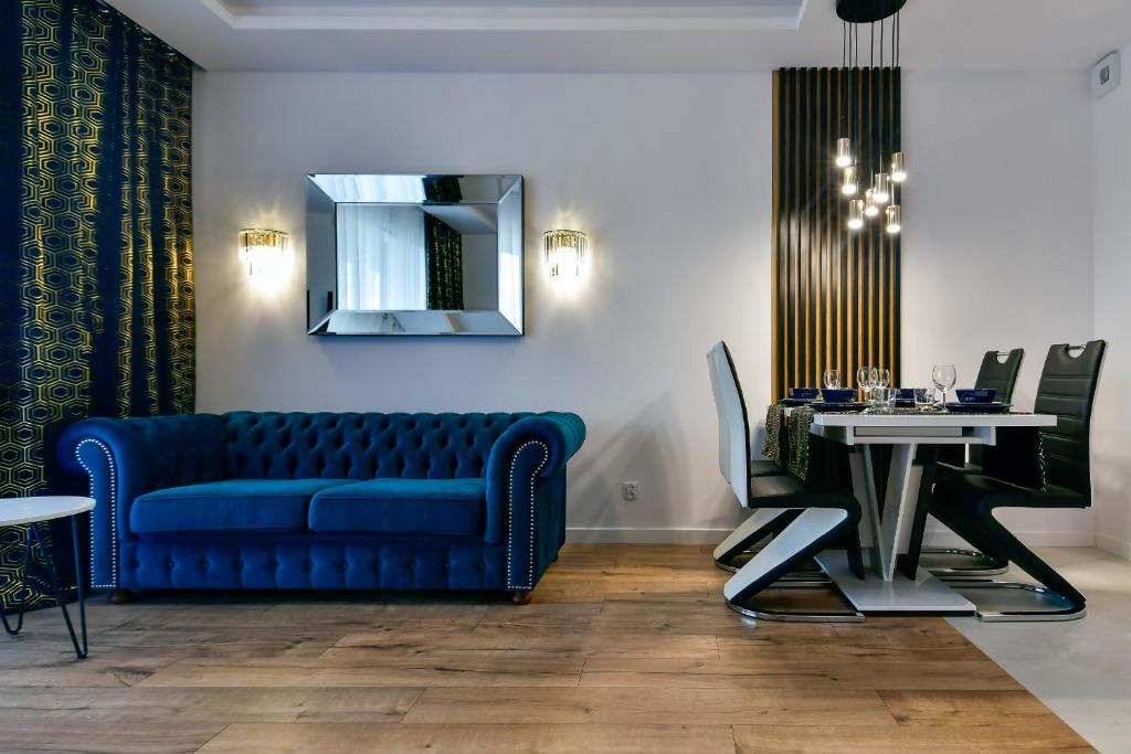 a living room with a blue couch and a table at Apartament32 Golden Vip -Duże Miejsce Postojowe- in Olsztyn