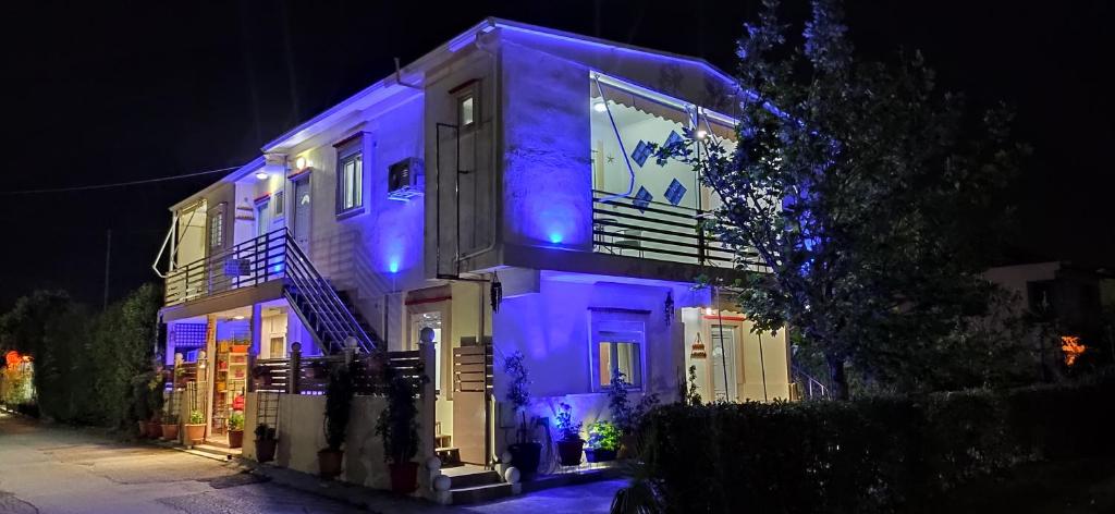 Una casa con luces azules encendidas por la noche en Kostas Apartments, en Kourouta