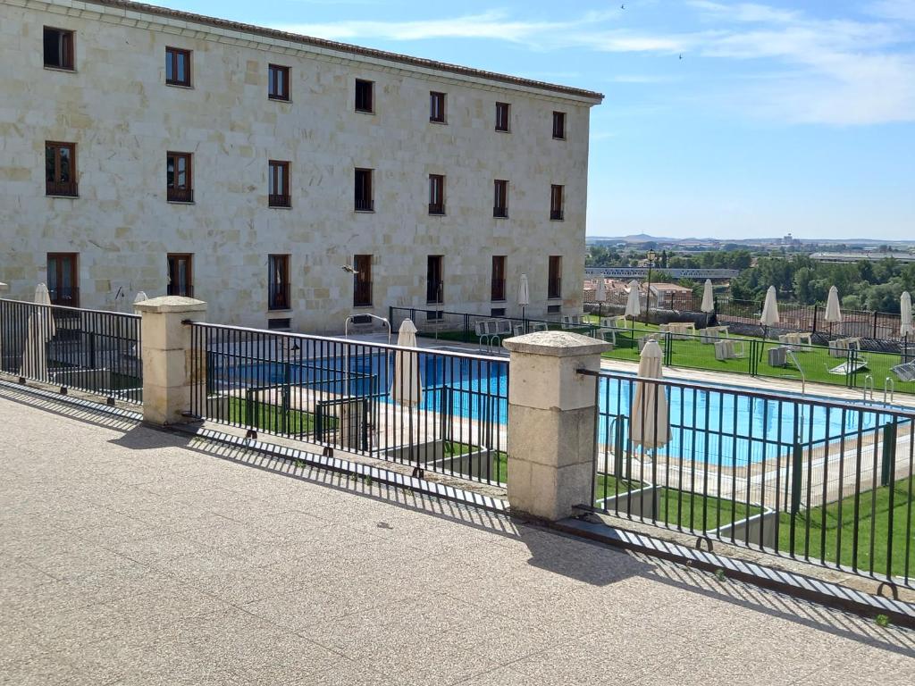 a fence in front of a building with a swimming pool at Parador de Zamora in Zamora