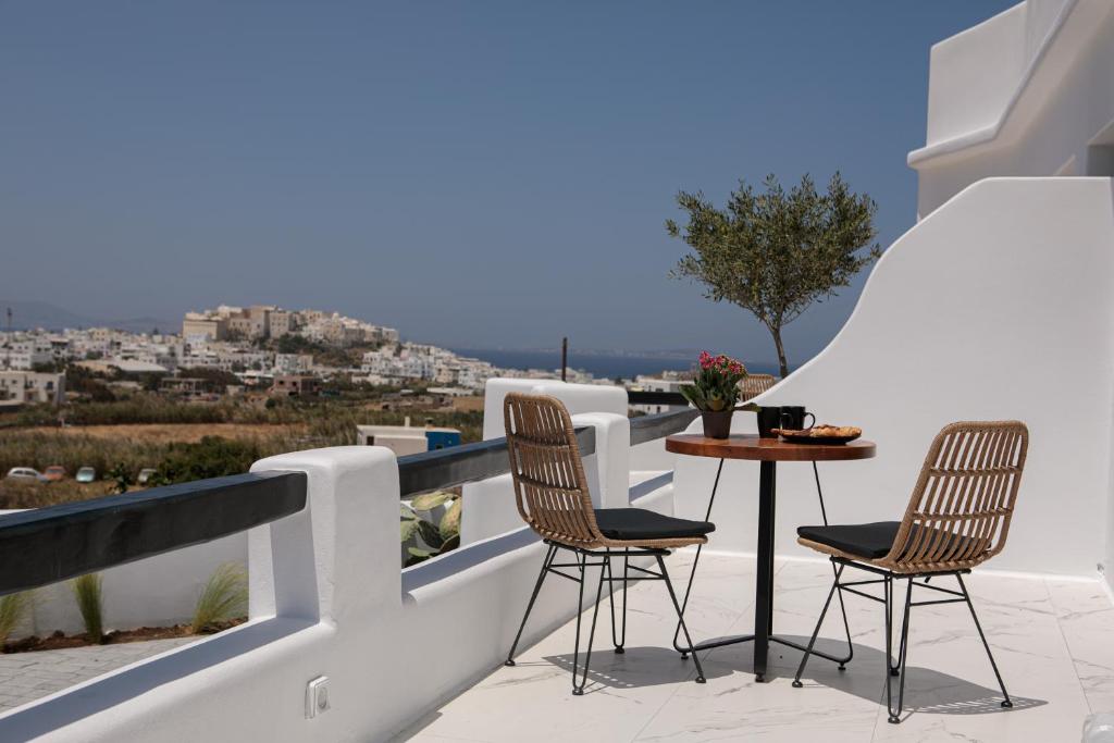 a patio with two chairs and a table on a balcony at Naxos White Concept in Naxos Chora