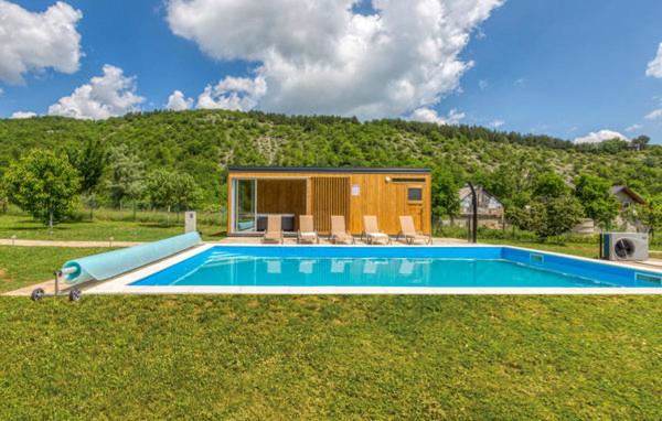 ein kleines Haus mit einem Pool im Gras in der Unterkunft Manuela in Gospić