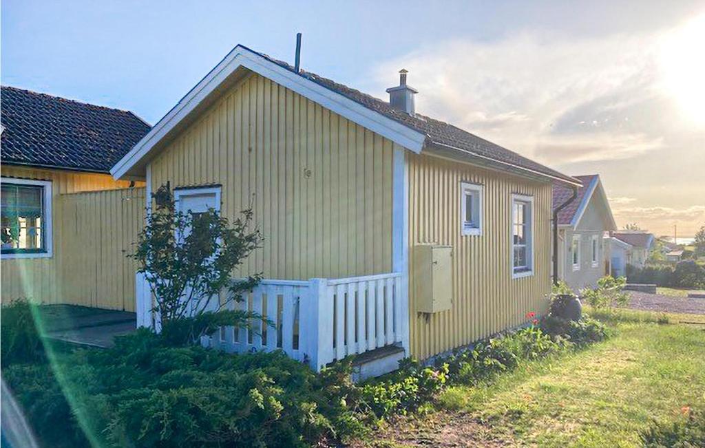 a small yellow house with a white fence at Lovely Home In Mrbylnga With Kitchen in Mörbylånga