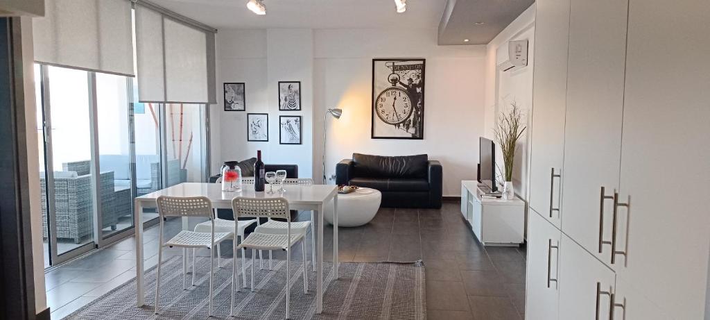 uma sala de estar com uma mesa e cadeiras e um sofá em Dezo Luxury town Apartment em Lárnaca