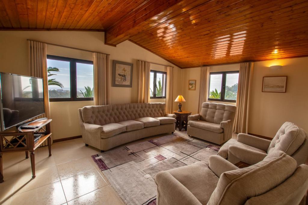 a living room with couches and a tv at A House With a View in Aljezur