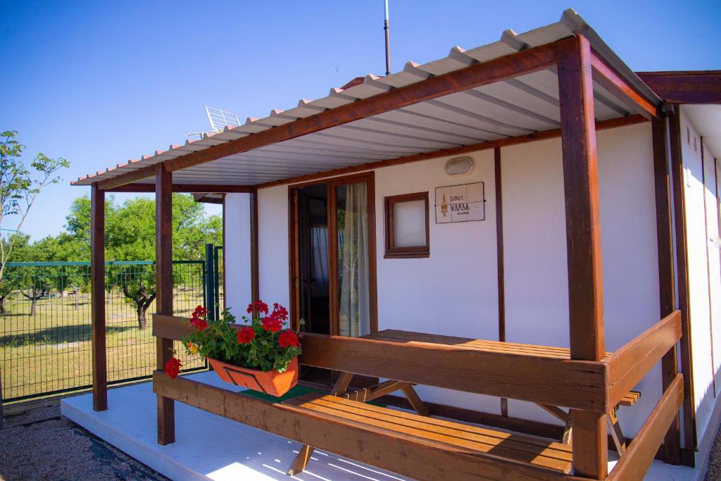 un pequeño edificio con un porche con flores en Las Casitas de Guadamur en Guadamur
