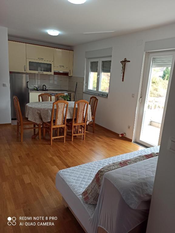 uma cozinha e sala de jantar com mesa e cadeiras em Apartman Marijana em Ljubuski