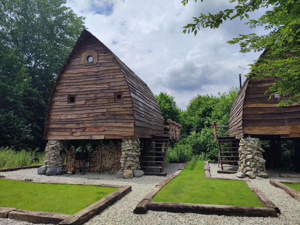 eine Scheune in einem Garten mit Gras in der Unterkunft Căsuțele de sub Șipote in Porumbacu de Sus