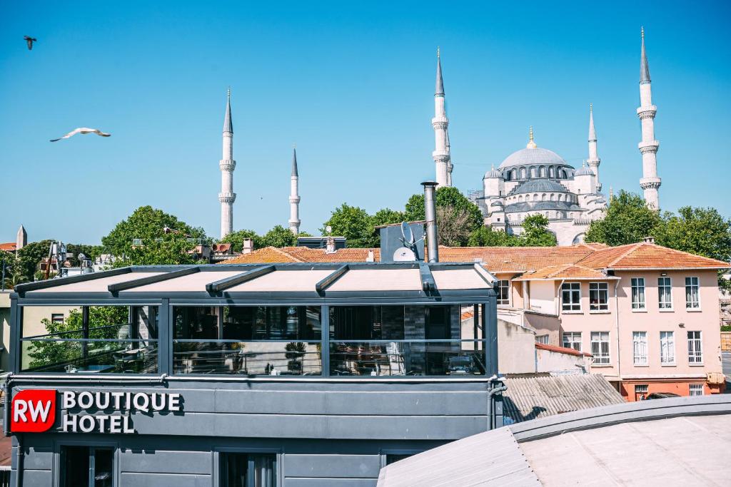 RW BOUTIQUE HOTEL في إسطنبول: باص بمبنى فيه مسجدين في الخلف