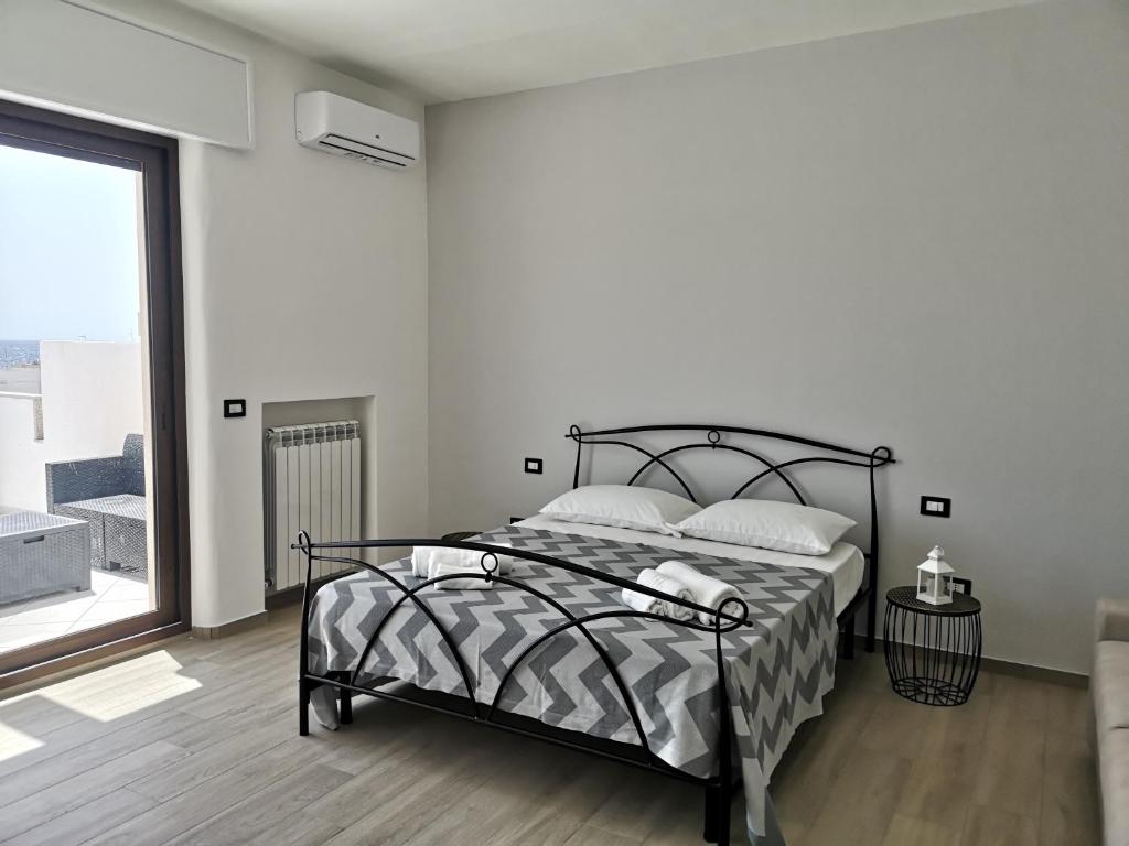 a bedroom with a bed and a large window at B&b tra scirocco e tramontana in Gallipoli
