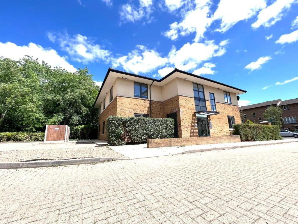 a large brick house with a brick driveway at Omega Inn in Milton Keynes