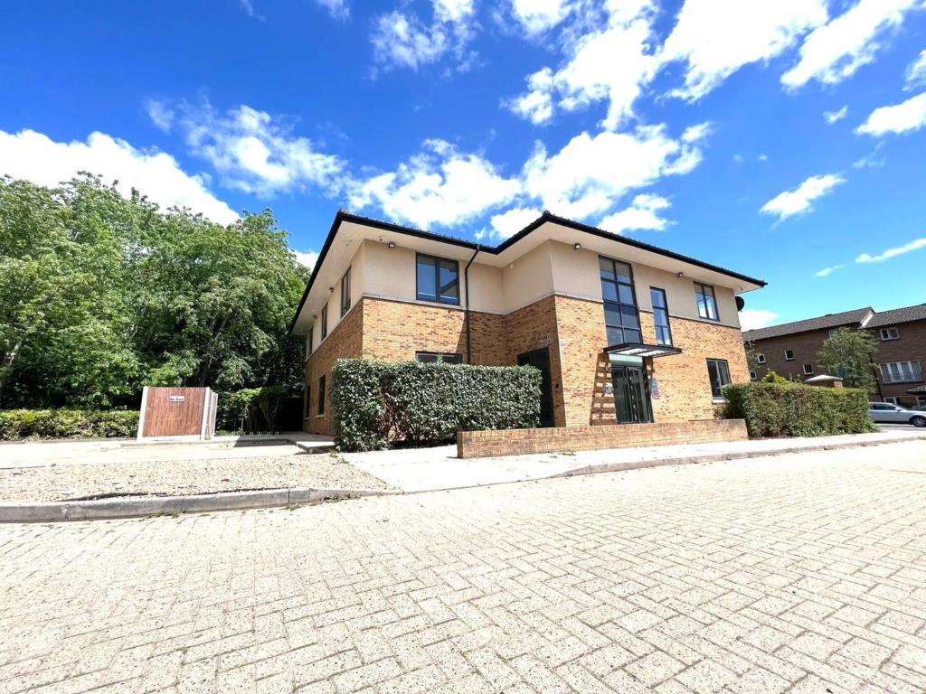 a large brick house with a brick driveway at Marvel Retreat in Milton Keynes